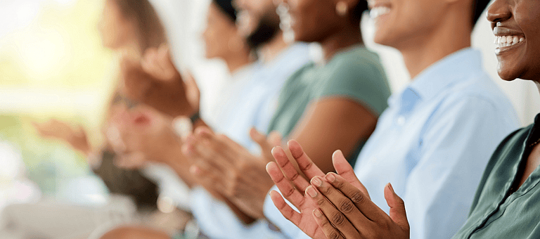 An audience applauds a doctor on their presentation